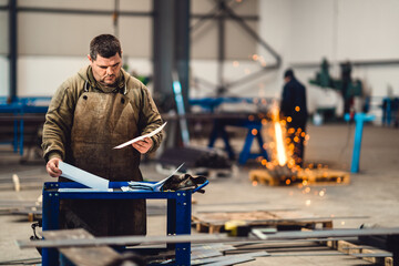 Industrial worker looking at blueprint