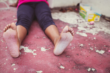 Young girl with chalky feet after playing hopscotch