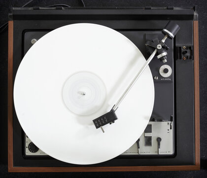 Vintage turntable with a white vinyl album playing