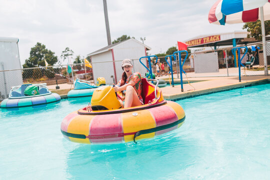 A Young Woman Plays Bumper Boats At An Amusement Park