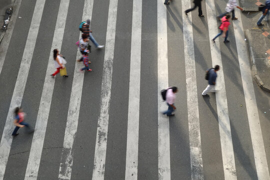 Crowd of pedestrians crossing busy intersection