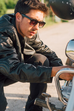 Young man checking engine on his bike