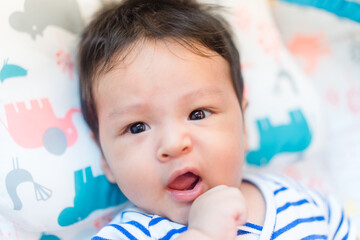 3 month baby boy kid on the bed.Looking camera and smile.Portrait infant baby child hungry milk.Breastfeeding kid.Adorable Mix race asian american kid with smile stay at home.Pediatric healthcare.