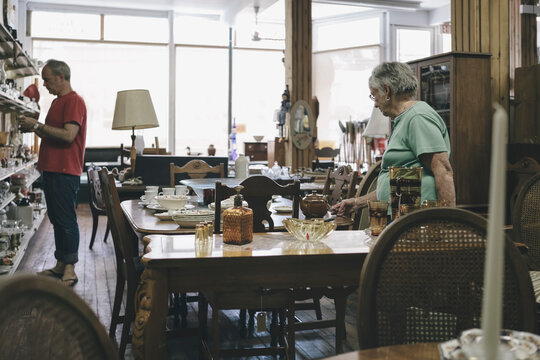 Senior Woman and Adult Son Browsing in Country Style Junk and Antique Shop