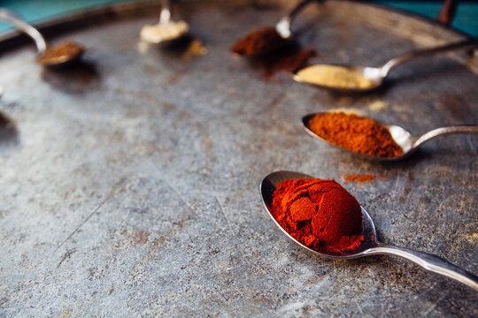 Various spices in spoons on a stone tray