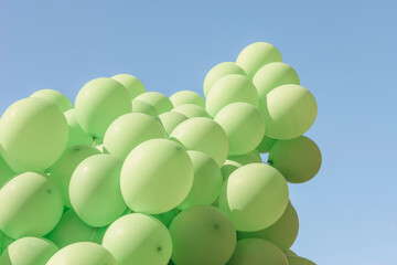 Bunch of Helium-Filled Green Balloons Against Blue Sky