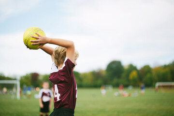 soccer player throwing the ball onto the field