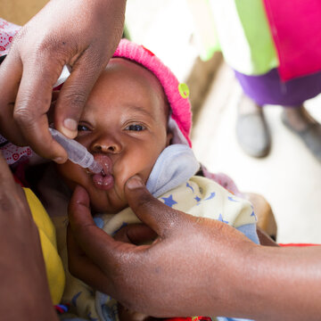 Baby receiving polio vaccine. Medical Clinic. Kenya. Africa.