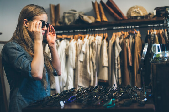 Young woman trying sunglasses in a vintage store