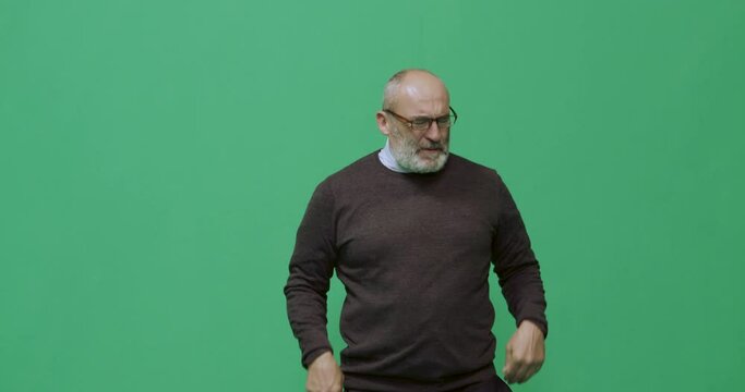 Studio, slow motion, green screen, an angry mature man reacts to a phone conversation, London, UK