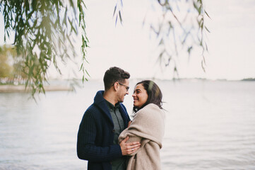 Coupling laughing and hugging under willow tree