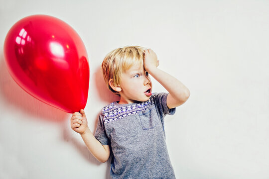 Child holding a red balloon