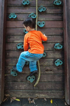 Young boy climbing up the wall