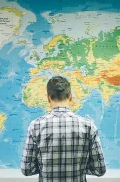 Man standing in front of huge world map.