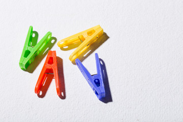 Colorful plastic clothespins for hanging clothes on white background