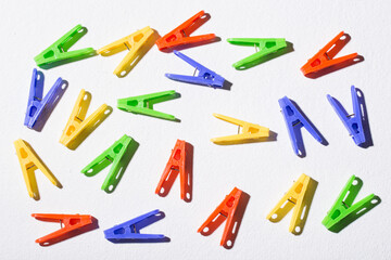Colorful plastic clothespins for hanging clothes on white background