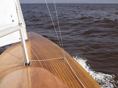 Waves breaking on the bow of wooden boat