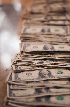 A long row of one dollar bills spread out on the table