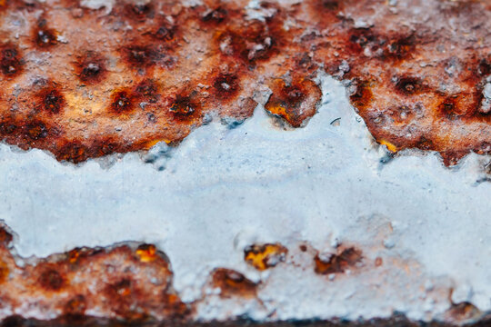 Macro of rust on painted metal railing