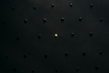 One golden pill stands out in a crowd of lots of back pills