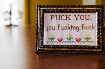 needlepoint saying in a frame