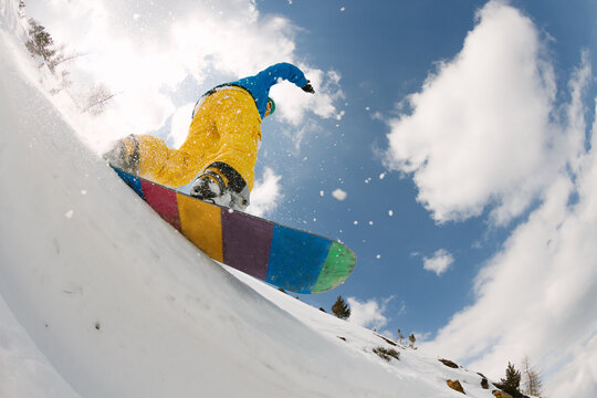 Young man snowboarding in powder snow