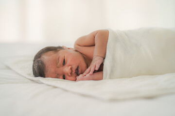 african american new born baby lying on white bed