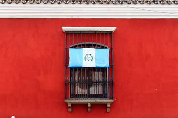 Guatemalan flag upside down on a window in antigua guatemala