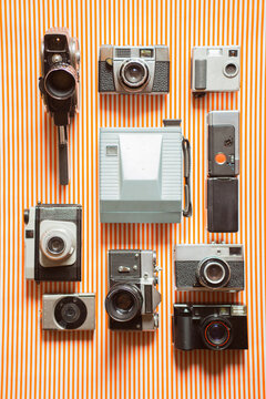 Collection of different cameras arranged on funky background.