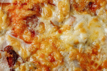 pizza with cheese, sauce and ham, bacon, salami on a gray dark background