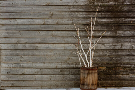 Birch branches gathered in rustic barrel decorated with tiny lights