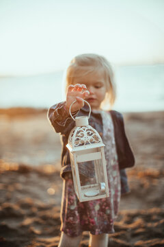 Toddler on the beach play with a latern