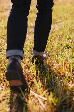 Close up of mens dress shoes walking through the grass