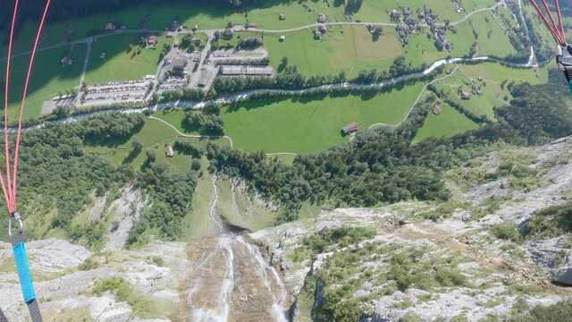 POV paragliding flight past waterfall in Lauterbrunnen, Swiss Alps