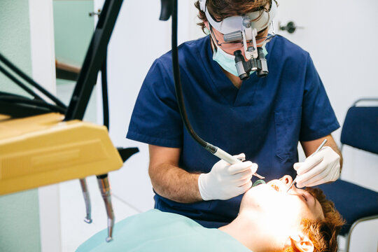 Dentist with microscope glasses during a root canal intervention