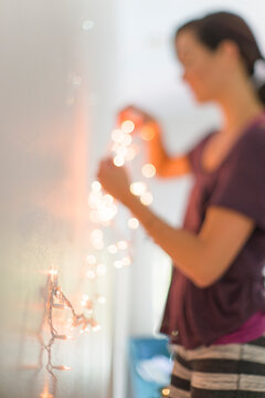 Defocused Shot of Woman Holding a String of White Christmas Ligh