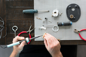 Man Repairing AC Appliance Motor With Soldering Iron