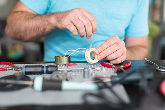 Man Repairing Electromagnet Coil from AC Appliance Motor