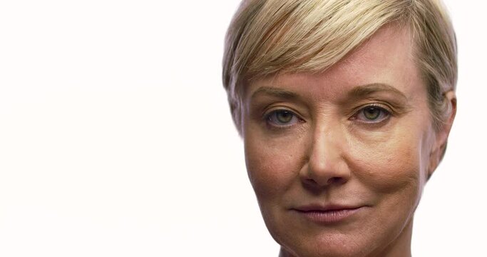 Close up of a woman looking into camera with a smirk