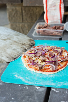 making pizza outdoors, simple ingredients of beef, onion and che