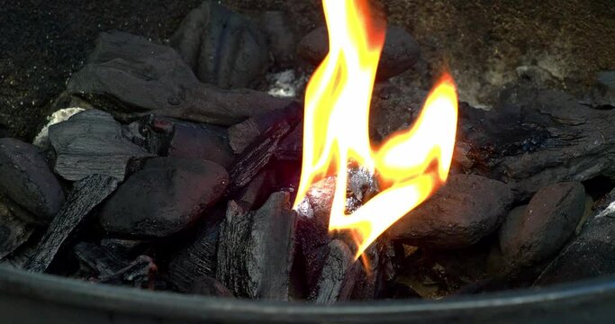 Lump coals on fire heating up to barbecue meat