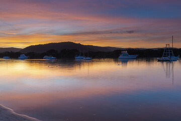 Sunset at the waterfront with high cloud and boats