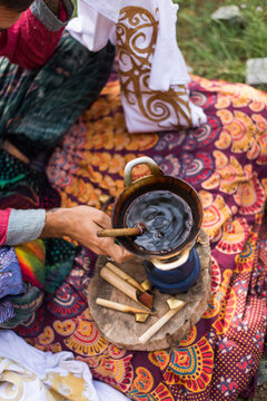Close up of young hippie man drawing some batik in nature