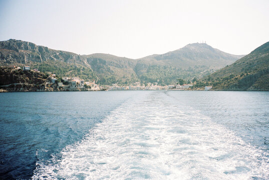 View from the rear of a boat with coast of Greek island