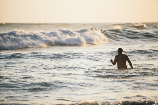 Man having a bath on the open sea with waves on the background