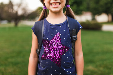 Six year old girl showing off her first missing tooth