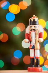 Traditional Christmas nutcracker with out of focus colored light background