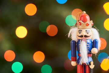 Traditional Christmas nutcracker with out of focus colored light background