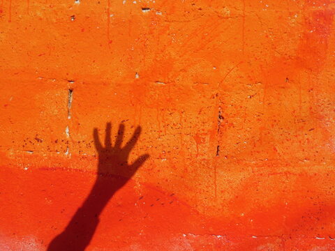 Human hand on red wall
