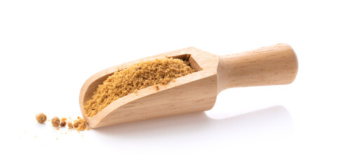 Brown cane sugar in wood scoop on white background